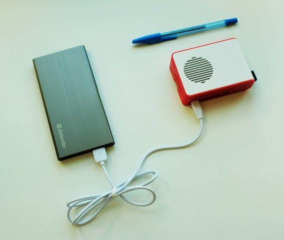 Малогабаритное устройство с подключением к power bank, рядом лежит ручка для сравнения с её размерами